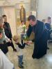 Дети и родители дарят цветы батюшке.